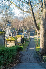 Paris, the Pere-Lachaise cemetery, cobbled alley with graves in winter
