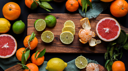 Frische Orangen auf schwarzem Hintergrund, Auswahl Orange, Mandarine, Zitrone, Limette, geschnittene und halbierte Früchte
