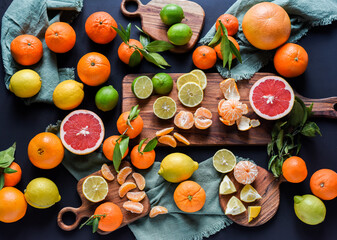 Frische Orangen auf schwarzem Hintergrund, Auswahl Orange, Mandarine, Zitrone, Limette,...