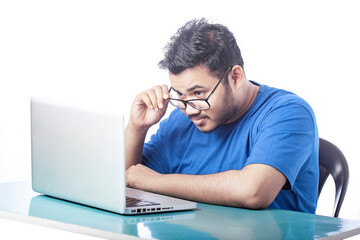 student looking at laptop screen with shocking expression
