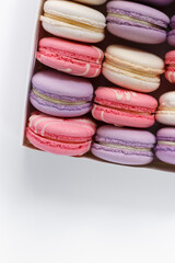 Closeup of cute pink and violet macaroons on box with space for text