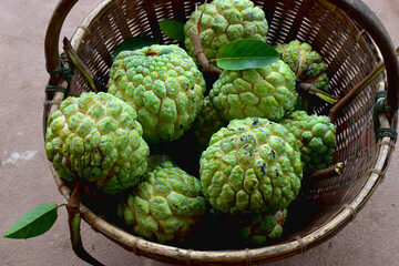 Custard apple, fresh and sweet tropical fruits in bamboo basket.
