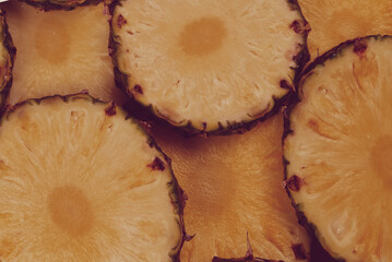 Pineapple juicy yellow slices background. Top view.