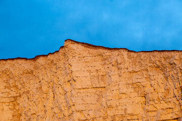 Looking up at Sussex coastal cliffs, with an orange glow at sunrise