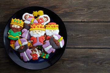Happy Epiiphany day. Homemade cookies in the shape of the three wise men on wooden background.