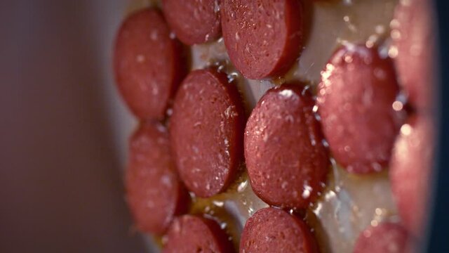 Turkish sausage is cooked in a pan in slow motion. One of the traditional Turkish breakfast dishes is eggs with sausage. Salami omelet.Macro, 4K, Phantom Camera,Close Up.Video for the vertical story.