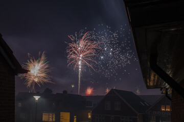 Decorative fireworks are set off between the houses