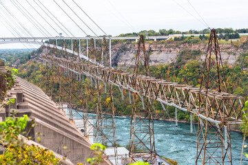 Electricity pylons supporting high voltage cables in a hydroelectric power plant along a river. Niagara Falls, ON, Canada.