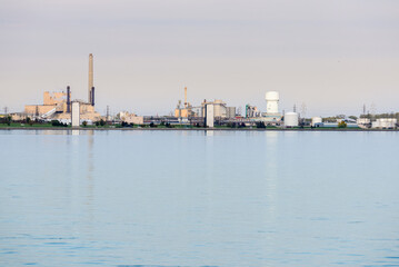 Fototapeta na wymiar Chemical plant along a river on a cloudy autumn day