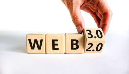 WEB 2.0 or 3.0 symbol. Businessman turns a wooden cube and changes words WEB 2.0 to WEB 3.0. Beautiful white table, white background, copy space. Business, technology and WEB 2.0 or 3.0 concept.