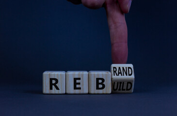 Rebrand and rebuild symbol. Businessman turnsa wooden cubes and changes the word rebrand to...