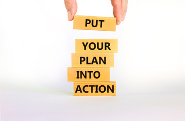 Put your plan into action symbol. Wooden blocks with words Put your plan into action. Beautiful white background, copy space. Businessman hand. Business, plan into action concept.