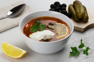 Traditional russian meat soup Solyanka in a bowl and ingredients