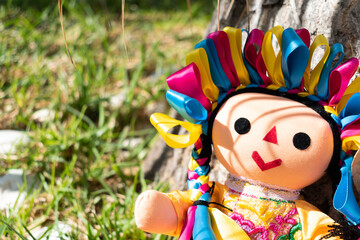 Otomi doll in a garden on a sunny day. Mexican culture.