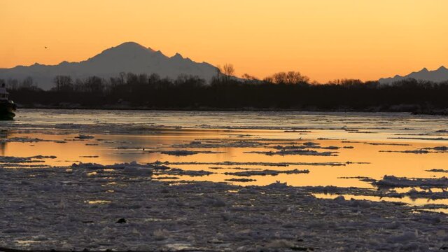 Fraser River Tugboat and Ice Floes 4K UHD. A tugboat and ice going down the Fraser River in winter. Richmond, British Columbia, Canada. 4K UHD.

