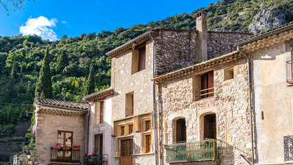 Fototapeta na wymiar Saint-Guilhem-le-Desert in France, view of the village, typical houses, with the mountain in background 