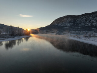 Sunrise over the river Hallingdalselva. Shot at Nesbyen, Norway. It is December and minus 20 degree outside. The water in the river is warmer than the air so therefor the smoke on the river. Frost. 