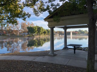 Beautiful park setting with gazebo and lake reflecting the trees.