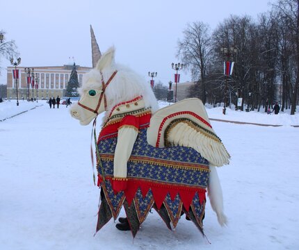 man in colorful unicorn costume on the city square at winter holiday