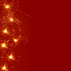 Creative background made of.sprinklers sparks on a red backgrund. Minimal Chinese New Year concept with copy space.
