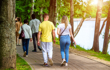 A guy and a girl walk along the path in the city Park
