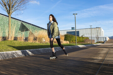 Woman skating / rollerblading in a modern area.