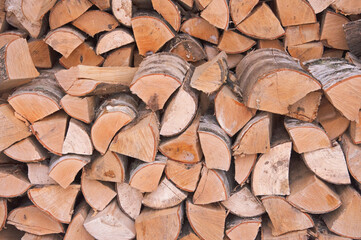 Birch chopped firewood for fireplace and stove stacked in rows close-up