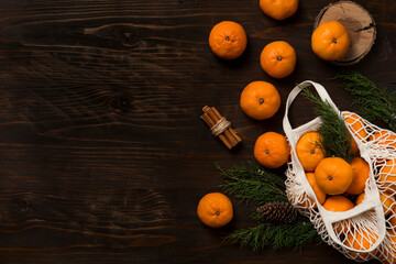 Fresh mandarin oranges fruit or tangerines on a wooden table. Christmas composition with tangerines, fir branches, cinnamon sticks. Flat lay, top view - 477521772