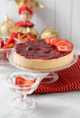 Whole strawberry cheesecake on the Christmas table. With dolls, and crystal accessories and decoration that reminds Christmas