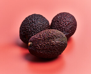  Three avocados fruit over red background