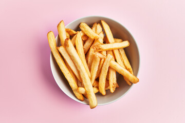  Bowl of french fried potatoes over pink background