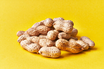  Bunch of peanuts with shell on a yellow background