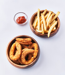  Bowls of breaded onion rings and potato chips isolated on a white background