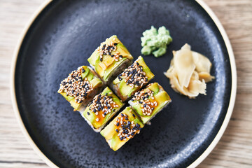  Plate of shrimp and cheese cream uramaki sushi on a wooden surface