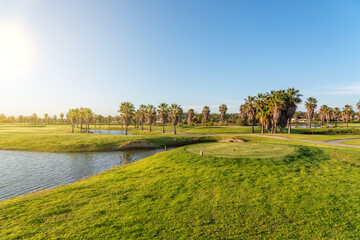 Obraz premium Modern golf courses for tourists with clear ponds and palm trees for relaxation and golf. Albufeira, Algarve Sunny day