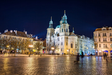 Fototapeta na wymiar Prague, Czech republic - December 29, 2021. Night photo of Old Town Square without Christmas markets banned due Coronavirus caused empty streets without tourists - St. Nicholas Church