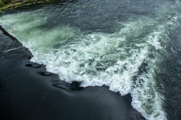 Fototapeta na wymiar Waterfall on the river Cávado river in Barcelos waves crashing on the rocks