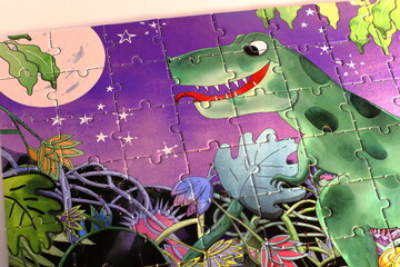Complete puzzle. Green dinosaur at night. Many small details. Children's puzzle entirely finished.