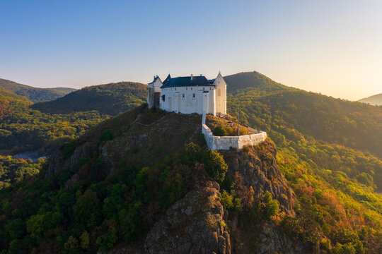 Splendid view about castle of Fuzer built on a volcanic hill named Nagy-Milic. Zemplen mountains at the background. Autumn sunrise landscape. 