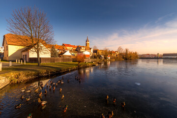 Fototapeta na wymiar Castle Park and Telc Castle. View of the city of Telc in the winter sunset. The picturesque castle and the historic center with the decorative facades of the houses belong to the UNESCO World Heritage
