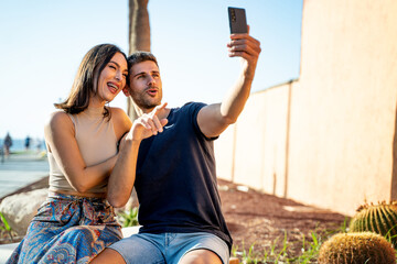 Young happy couple taking selfie with mobile phone, smiling to the smartphone. Summer time. Vacation. Traveler.