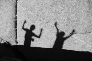 children playing with shadow at a rock in Joshua tree national park