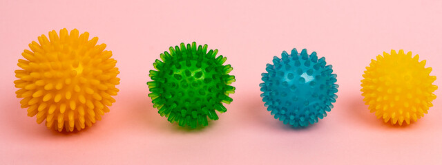 colored massage needle balls of different sizes on a pink background, the concept of prevention of flat feet, hallux valgus, banner