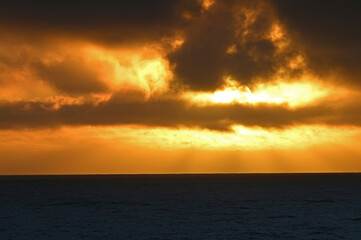 Naklejka na ściany i meble Large sun ball at sunset over Pacific Ocean seascape.