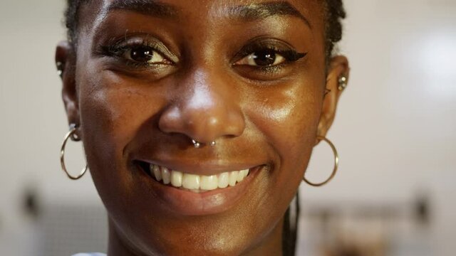 African american woman portrait. Female person smiling, looking in camera. Close-up of happy face. Pretty latin model with wide smile, having nose piercing.