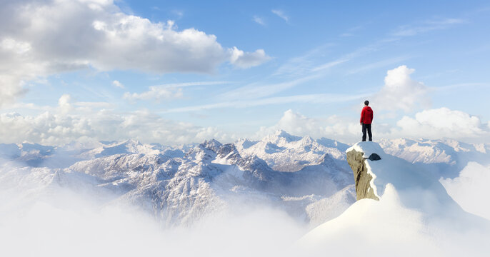Adult adventurous man standing on top of a snow peak. Winter Wonderland. 3d rendering mountain adventure artwork. Aerial landscape from British Columbia, Canada. Blue Cloudy Sky