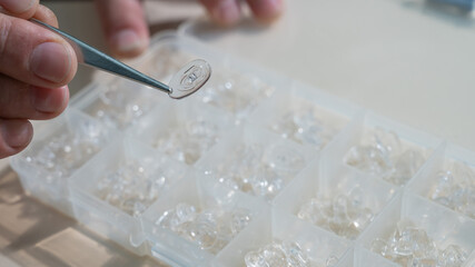 Installation of nose pads in glasses. A male technician repairs broken glasses