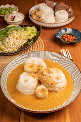 Rice noodles or Kkanomjeen namya krati in fish curry sauce with vegetables, Rice vermicelli with minced fishes and coconut milk in red curry.