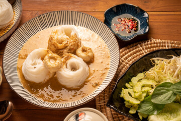 Rice noodles or Kkanomjeen namya krati in fish curry sauce with vegetables, Rice vermicelli with minced fishes and coconut milk in red curry.