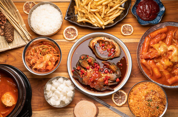Korean traditional food Kimchi soup with Tofu mushroom hot pot, Kimchi soup in hot iron pot with rice and Kimchi pickle on wooden table,